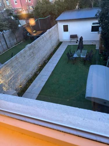a backyard with a retaining wall and a yard with chairs at Elsaro in Slough