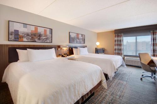 a hotel room with two beds and a window at Hilton Garden Inn Terre Haute in Terre Haute