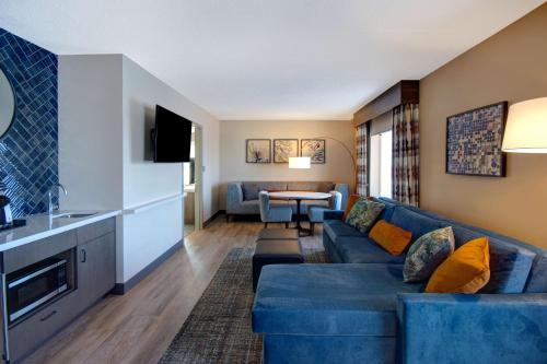 a living room with a blue couch and a table at Hilton Garden Inn Terre Haute in Terre Haute