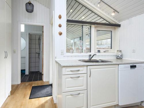 Holiday home Ansager X في Ansager: مطبخ أبيض مع حوض ونافذة