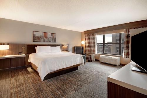um quarto de hotel com uma cama e uma grande janela em Hilton Garden Inn Terre Haute em Terre Haute
