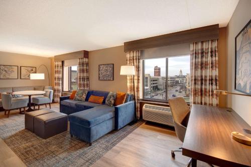 a living room with a blue couch and a table at Hilton Garden Inn Terre Haute in Terre Haute