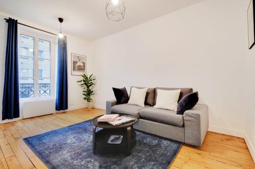 uma sala de estar com um sofá e uma mesa em Beautiful Luxury Appartement em Levallois-Perret