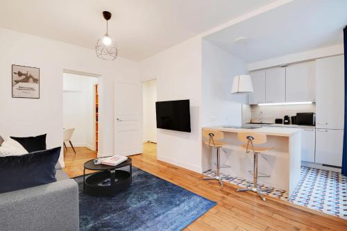 uma sala de estar com um sofá e uma cozinha em Beautiful Luxury Appartement em Levallois-Perret