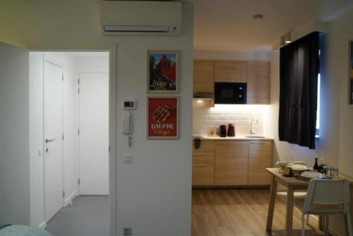 um quarto com uma cozinha com uma mesa e uma porta em Arku apartments Brussels Airport em Zaventem