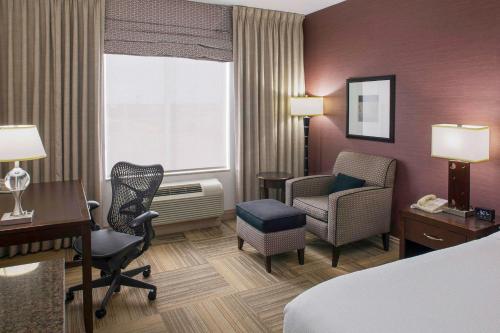 a hotel room with a bed and a desk and chair at Hilton Garden Inn Jonesboro in Jonesboro