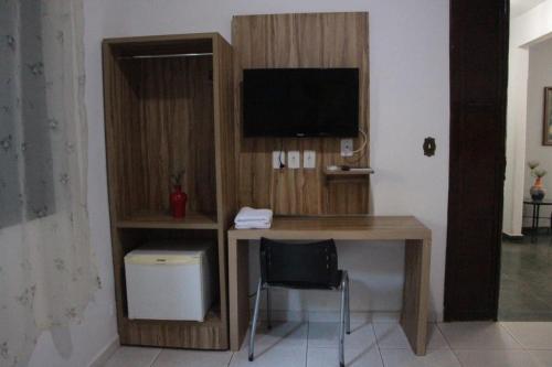 a room with a desk with a computer and a television at Hotel Serras De Goyaz Bueno, Goiânia in Goiânia