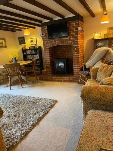a living room with a couch and a fireplace at Strongate Cottage Rural Retreat - near Bridport & Jurassic Coastline in Netherbury