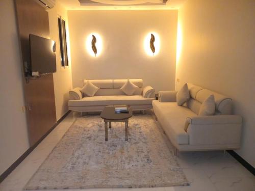 a living room with two couches and a table at ضيف بارك للشقق المخدومة in Ad Dawādimī