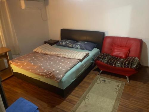 a small bedroom with a bed and a chair at Una Maria rooms in Podgorica