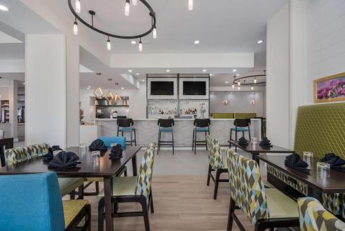 Hilton Garden Inn Oklahoma City Midtown في مدينة اوكلاهوما: مطعم به طاولات وكراسي وبار