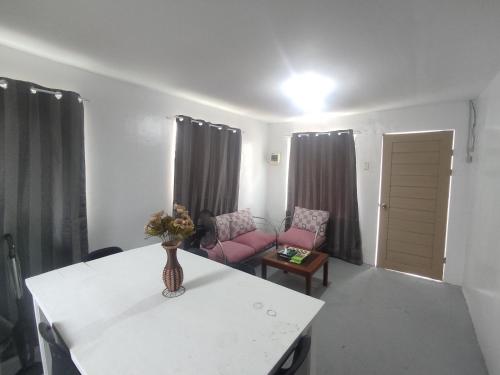 - un salon avec une table et un canapé rose dans l'établissement Enzo's transient house, à Davao