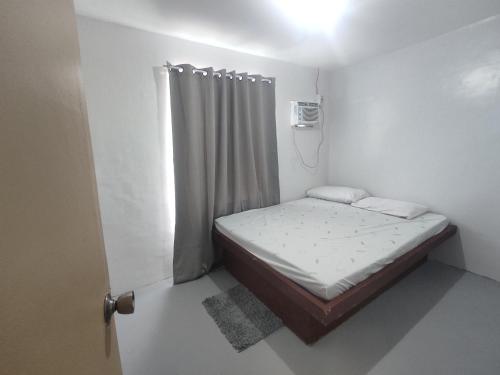 - un petit lit dans une petite chambre avec fenêtre dans l'établissement Enzo's transient house, à Davao