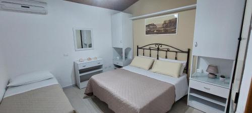 a small white bedroom with a bed and a window at Residenza La Grazia Tropea - Free Parking - in Tropea