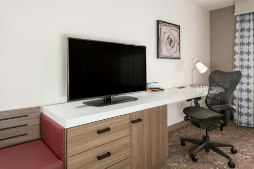 a room with a desk with a television and a chair at Hilton Garden Inn Scottsdale North/Perimeter Center in Scottsdale