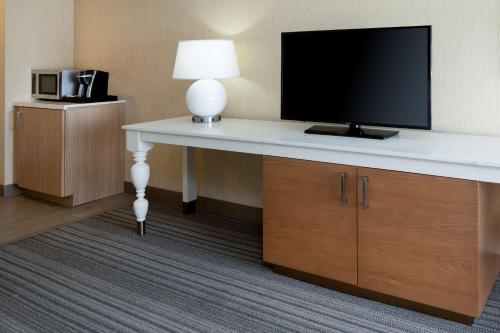 a room with a desk with a television on it at Hilton Garden Inn Roseville in Roseville