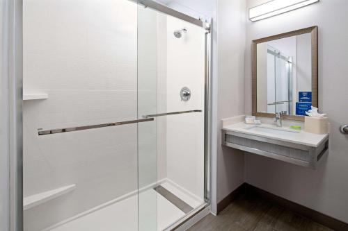 a bathroom with a shower and a sink at Hilton Garden Inn Roseville in Roseville