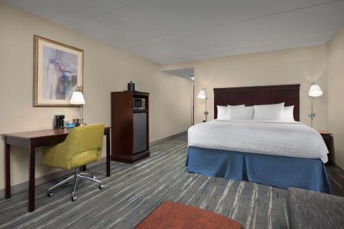 a hotel room with a bed and a desk and a bed sidx sidx at Hampton Inn Syracuse Clay in Liverpool