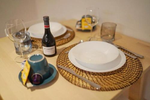 a table with two plates and a bottle of wine at Arku apartments Brussels Airport in Zaventem