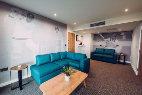 a living room with a blue couch and a table at Hilton Garden Inn Manchester Emirates Old Trafford in Manchester