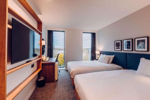 a hotel room with two beds and a flat screen tv at Hilton Garden Inn Manchester Emirates Old Trafford in Manchester