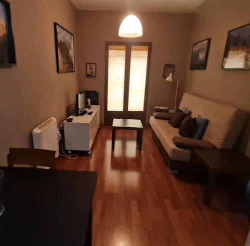 uma sala de estar com um sofá e uma mesa em El Cervunal em Arenas de San Pedro