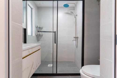 a bathroom with a shower and a toilet and a sink at Laurel Hill Suites in Nairobi