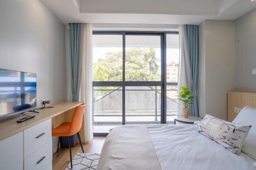 sypialnia z łóżkiem, biurkiem i oknem w obiekcie Laurel Hill Suites w mieście Nairobi