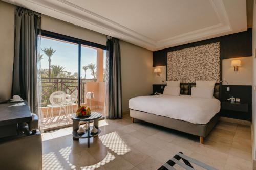 um quarto com uma cama e uma grande janela em Barceló Palmeraie em Marrakech