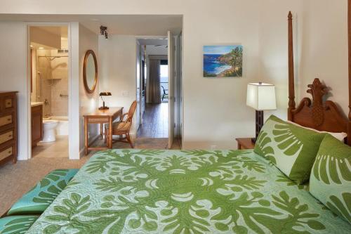 a bedroom with a large bed and a bathroom at The Cliffs Club at Princeville in Princeville