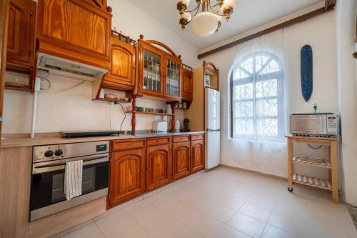 eine große Küche mit Holzschränken und einem Fenster in der Unterkunft Villa Butterfly in Budapest