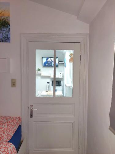 a door with a window and a tv in a room at Maison LYDIE - Meublé de vacances 3 étoiles in Charleroi