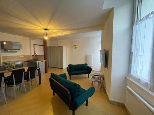 Una sala de estar con un sofá y sillas y una mesa. en Logement familial 3 chambres 2 wc 2 sdb Futuroscope Arena Aquascope Palais des Congrès, en Jaunay-Clan