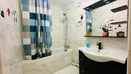 une salle de bain avec un lavabo, une douche et une baignoire dans l'établissement paris holiday, à Aubervilliers