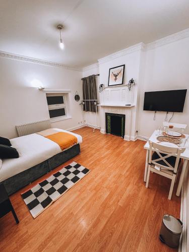 a bedroom with a bed and a desk and a tv at Spacious 3 rooms in Tooting in London