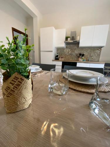 einen Tisch mit Tellern und Gläsern und eine Pflanze darauf in der Unterkunft Casa Oasi in Seriate
