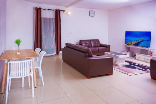 - un salon avec un canapé et une table dans l'établissement J&G Premier Apartment, à Yaoundé