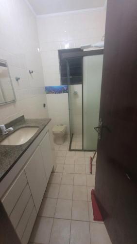 a bathroom with a sink and a toilet at Apartamento em peruibe in Peruíbe