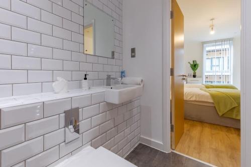 baño blanco con lavabo y cama en Comfy • Quiet • Your Other Home, en Birmingham