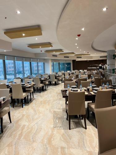 a dining room with tables and chairs and windows at Nozha Beach - Ras Sudr in Ras Sedr