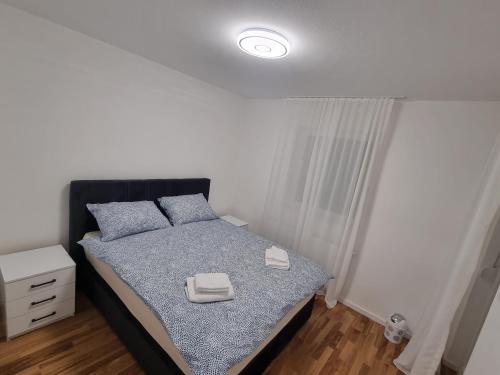 - une chambre avec un lit doté d'une tête de lit noire dans l'établissement Apartman Panorama Doboj, à Doboj