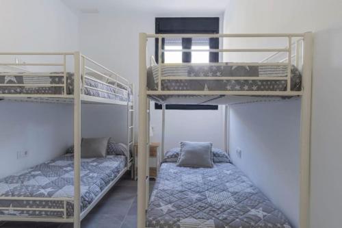 Zimmer mit 2 Etagenbetten und einem Bett in der Unterkunft VILLA caracolillo MAR in Chiclana de la Frontera