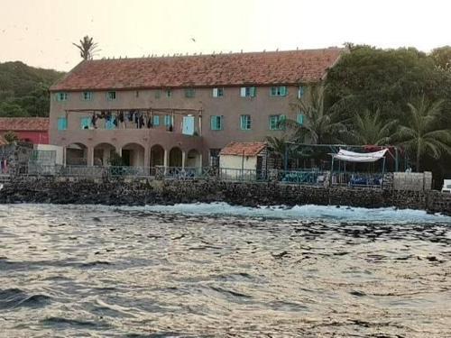 a house on the shore of a body of water at Auberge Mariama BA in Gorée
