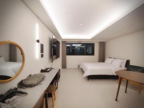 仁川にある인천 연수 블루버드호텔 Bluebird Hotelのベッド2台と鏡が備わるホテルルームです。
