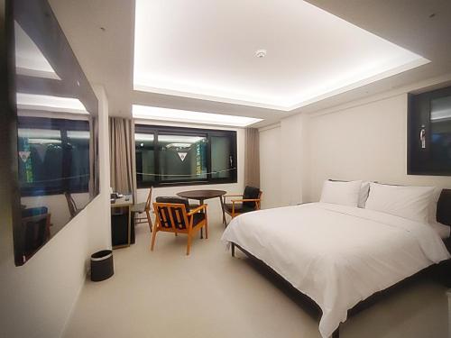 a bedroom with a bed and a table and chairs at Bluebird Hotel in Incheon
