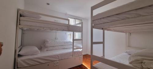 two bunk beds in a room with a window at Owls Hostel Ribeiro in Porto
