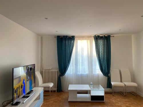 een woonkamer met een tv en een tafel bij Appartement Amaya 1 - 100 m2 Paris 2024 in Pontoise