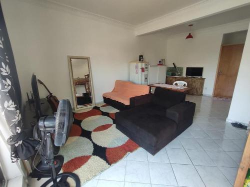 uma sala de estar com um sofá e um espelho em Residência RCA13 em Santos