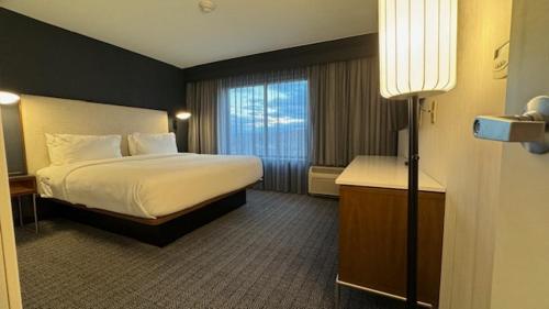 a hotel room with a bed and a window at Courtyard by Marriott Kingston in Kingston