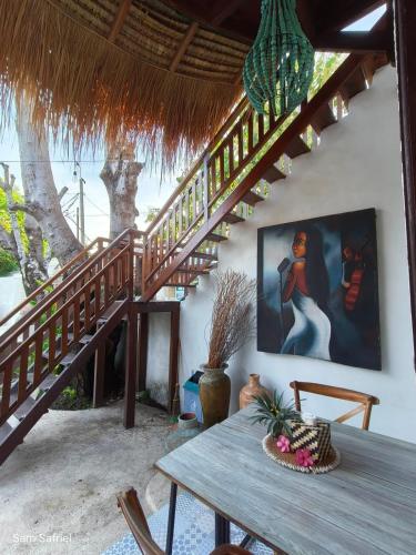 a dining room with a wooden table and stairs at Gili Breeze Tropical Bungalows in Gili Trawangan